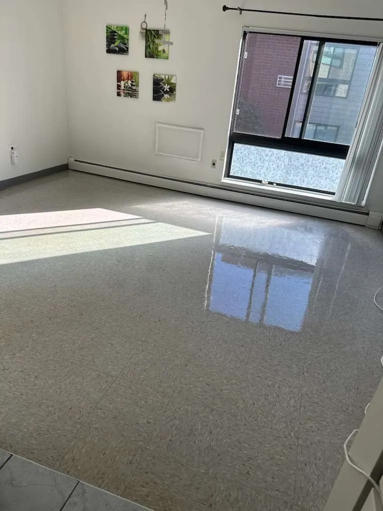 Stripped and refinished vinyl floor reflecting window light