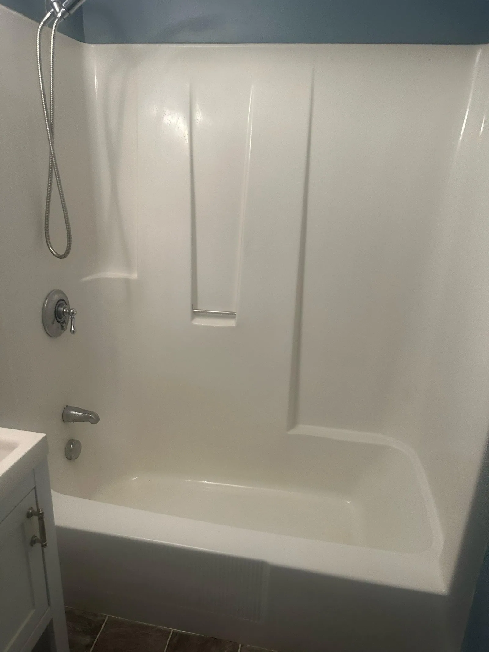 Clean bathtub and shower surround in a bathroom