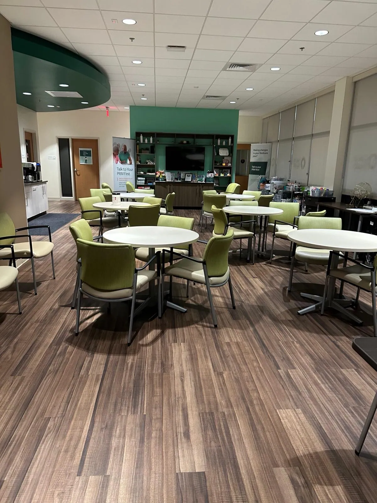 Break room with wood-look flooring and round tables